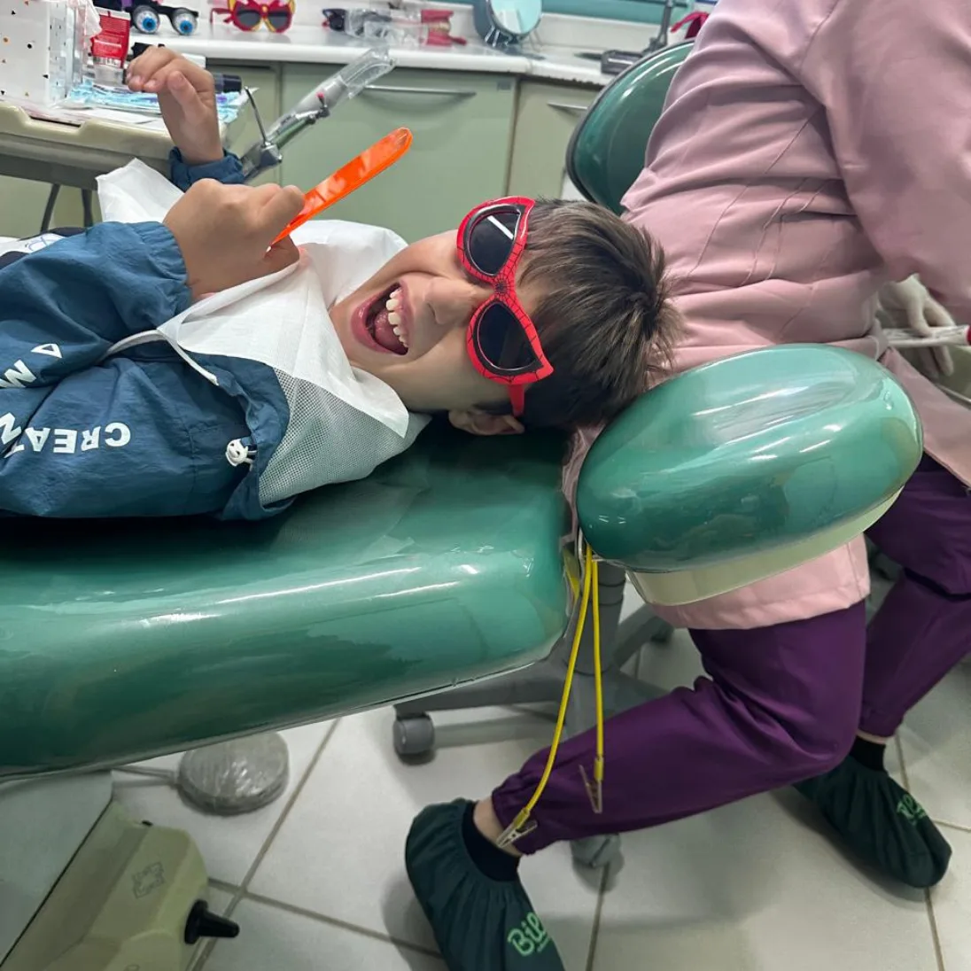 Criança sorrindo durante atendimento odontopediátrico