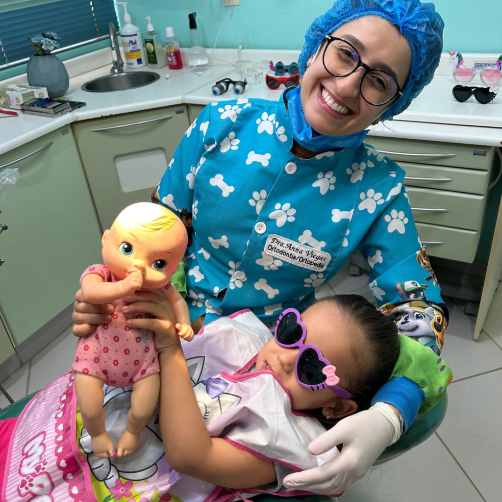 Dra. Anna Viegas com paciente infantil em atendimento lúdico na Billig Odontologia - dentista infantil Asa Norte Brasília