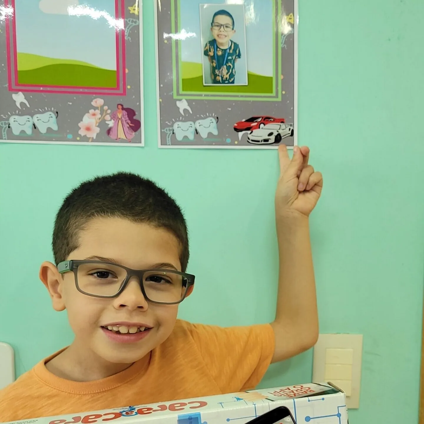 Paciente infantil sorrindo com brinde do consultório