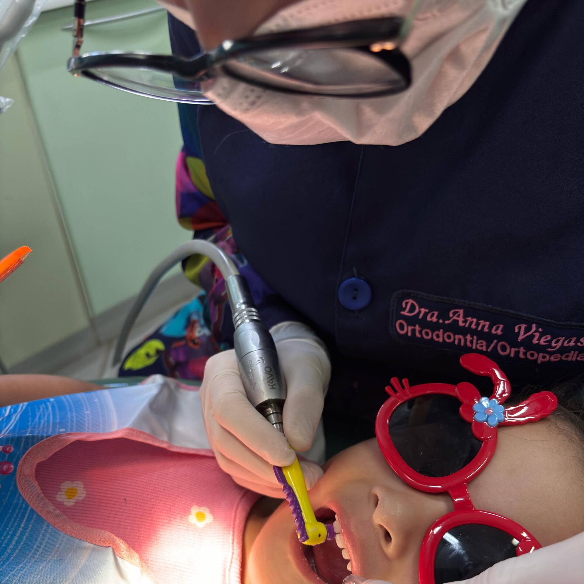 Ortodontista realizando procedimento ortodôntico em paciente infantil com aparelho dental no consultório